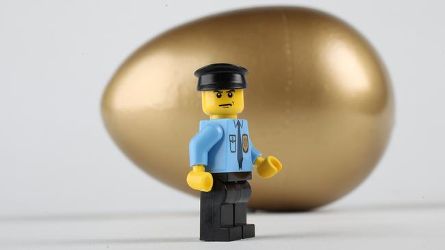 Money squeeze - man Lego piece and golden nest egg.