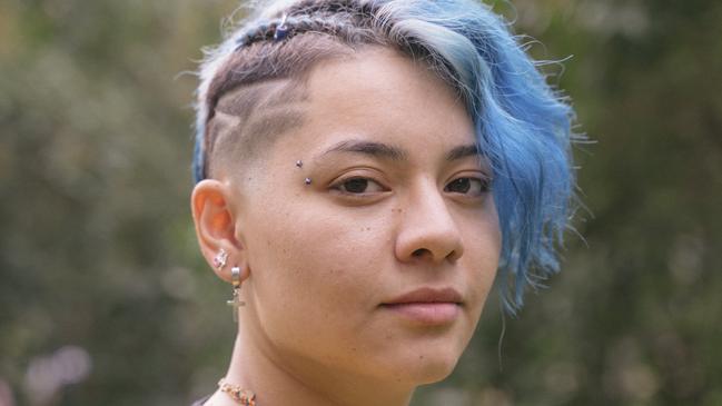 Young cheerful woman with expression of sadness and blue short hair. transgender stock image