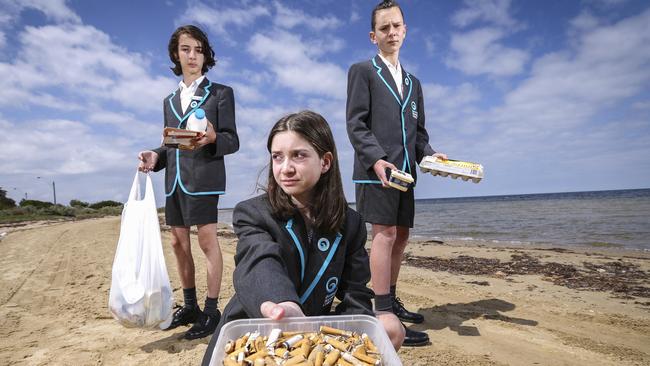 Beaumaris Secondary College students Alex Stefanatos, Ellen Quinn and Nathan Palmer help clean up the beach. Picture by Wayne Taylor