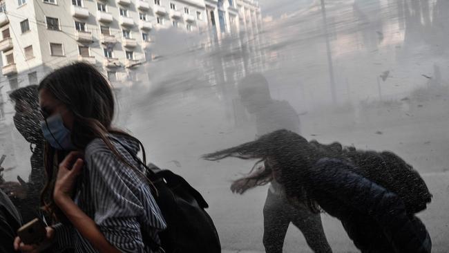 Protesters run from tear gas and water cannons in Athens overnight (AEDT). Picture: AFP