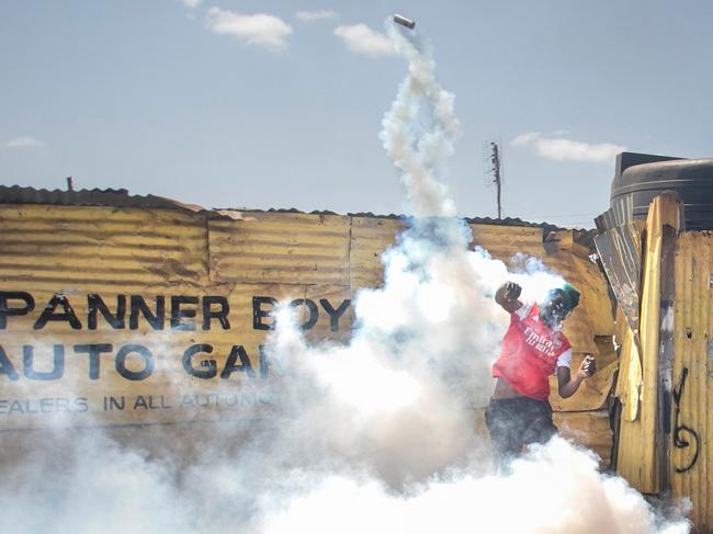 A protester hurls a tear gas canister back towards Kenyan police on the third day of confrontations between authorities and supporters of the Kenyan opposition during anti-government protests in Kibera, Nairobi. Picture: Tony Karumba / AFP