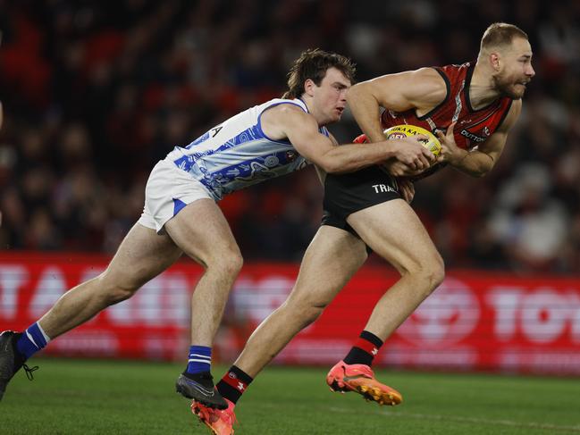 MELBOURNE , AUSTRALIA. May 19, 2024.  AFL round 10Ã  Essendon vs North Melbourne at Marvel Stadium .   Ben McKay of the Bombers  charges forward as George Wardlaw of the Kangaroos tries to halt his progress   . Pic: Michael Klein