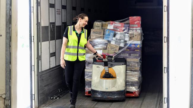 Woolworths has taken delivery of 448 pallets of groceries for their Far North Queensland stores, after flooding rains cut the road network and stopped deliveries. Woolworths Cairns Central assistant store manager Lauren Oxenham removes pallets of food off the truck on Thursday morning. Picture: Brendan Radke