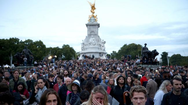 People react outside Buckingham Palace to the news of the Queen’s death. Picture: Reuters