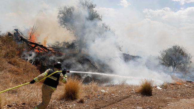 Firefighters douse flames in a field after a drone launched from southern Lebanon fell near Senir Kibbutz in the Upper Galilee in northern Israel. Picture: AFP