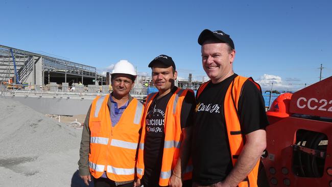 Fast-food outlet Carl Jr is opening at Hope Island Marketplace. From left are Bansal Group’s Premnath and Gaurav Bansal and Shawn Kerr. Picture Mike Batterham