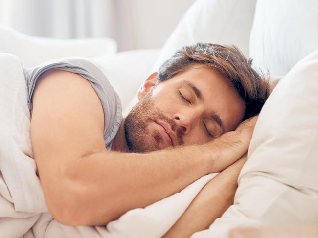 Home, bedroom and sleeping man in the morning lying his head on the pillow in apartment space. Tired, fatigue and relax male taking time off on the weekend in bed of airbnb or hotel accommodation