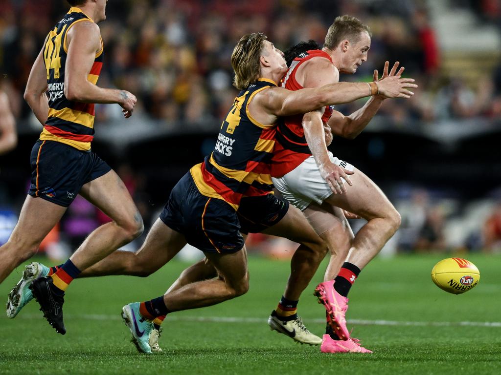 Josh Worrell tackles Essendon’s Mason Redman at the Adelaide Oval on Friday night. Picture: Mark Brake/Getty Images.