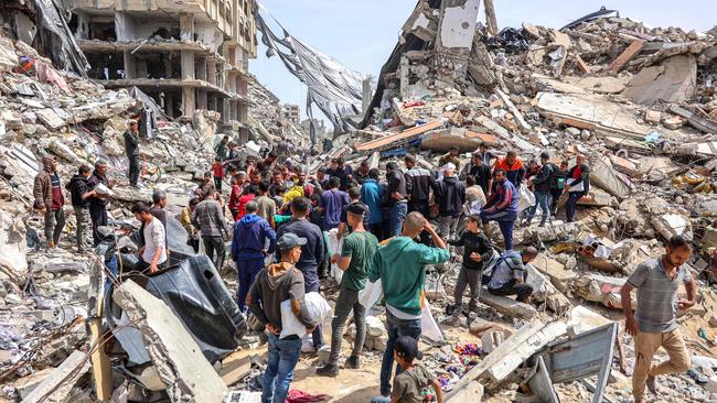 People gather by a destroyed building at the site of a drop of humanitarian aid in the northern Gaza Strip. Picture: AFP