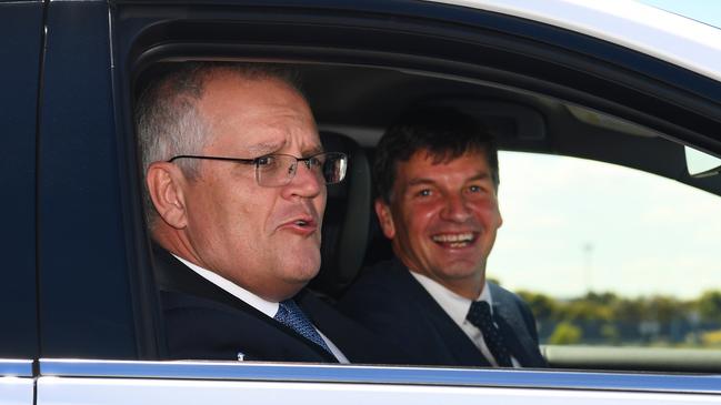 Australian prime minister Scott Morrison (L) and Australia's Minister for Energy and Emissions Reduction Angus Taylor (R) drive a hydrogen-fuelled car around a Toyota test track in Melbourne in Melbourne on November 9, 2021.  Morrison visits the Toyota Hydrogen Centre in Altona to unveil a new $250m electric vehicle plan.