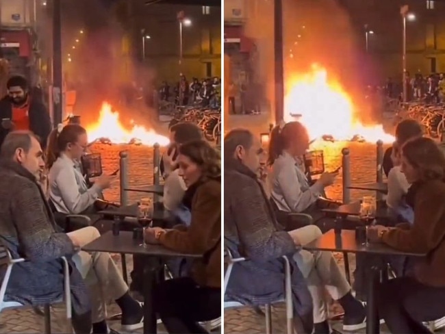 French patrons watch on as bonfire burns.