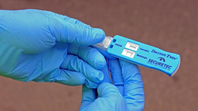 A police officer holds a random drug test device. File photo