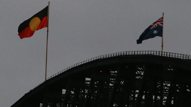 The Aboriginal flag flew alongside the Australian flag on top of the Sydney Harbour Bridge on Australia Day. Picture: Lisa Maree Williams/Getty Images