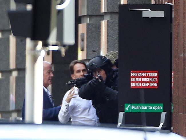 Hostages John O'Brien and Stefan Balafoutis run to the safety of police after escaping the Cafe. Picture: Craig Greenhill