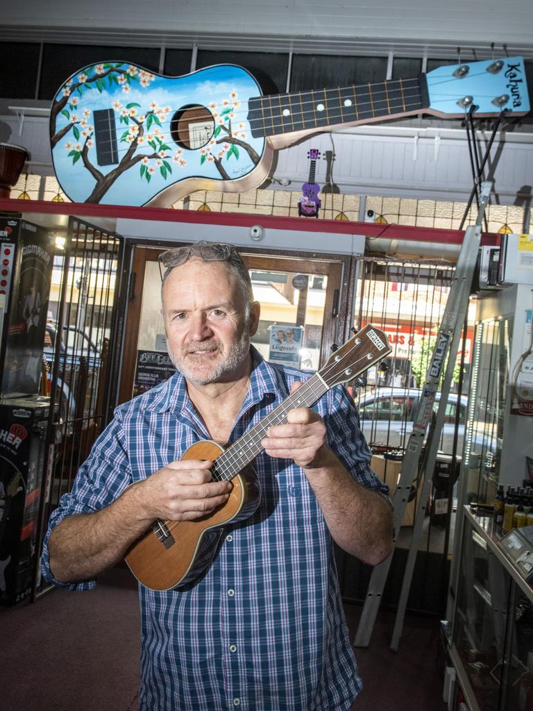 Tony Watson with the giant ukulele he made for a friend. It now resides at Bandland in Russell St. Picture: Nev Madsen