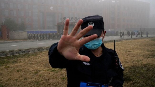 A security person moves journalists away from the Wuhan Institute of Virology in February 2021. Picture: AP