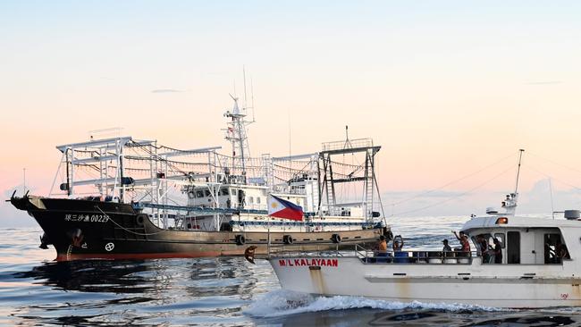 A Chinese vessel, left, identified by the Philippines as ‘maritime militia’ blocks the ML Kalayaan chartered supply boat in the South China Sea last week. Picture: AFP