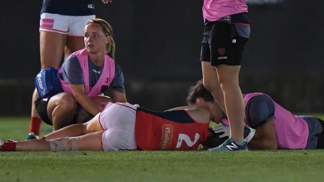 Trainers attend to Meg Downie after she was knocked out by Sophie Casey.