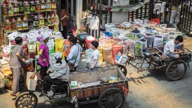 Customers with carts gather round a grain store at a wholesale market in Shanghai. Picture: Bloomberg