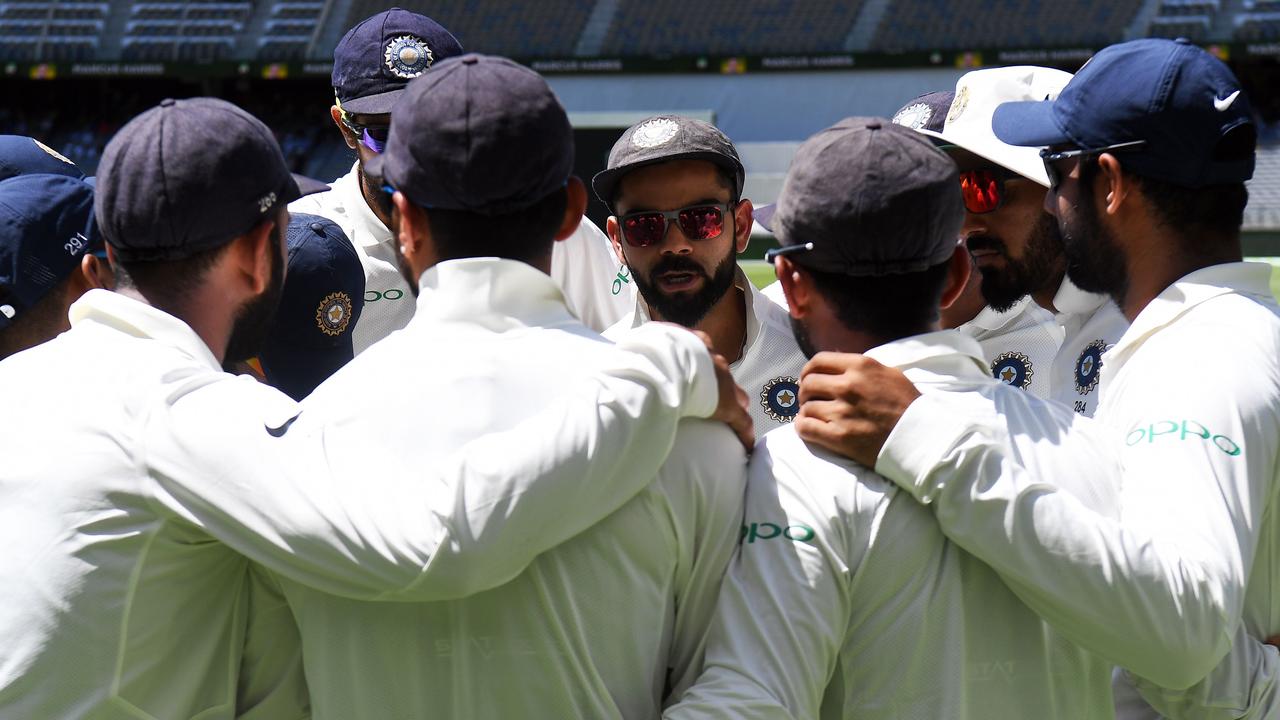 India's cricket captain Virat Kohli talks to teammates.