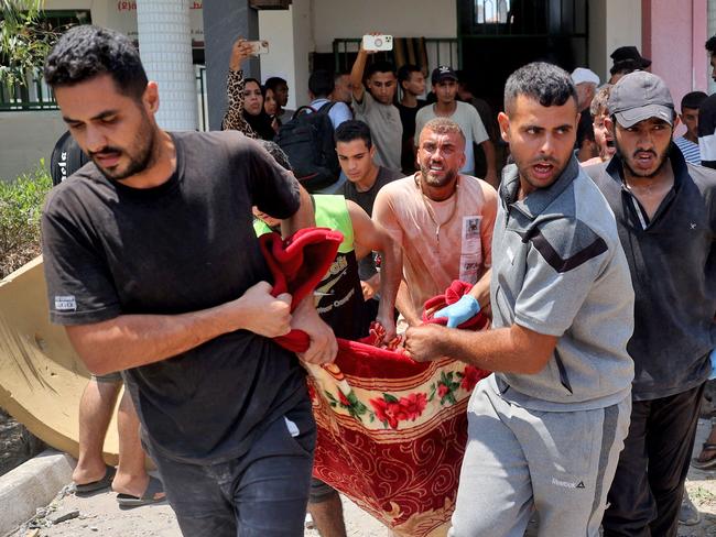 People carry a person injured during an Israeli strike on the Khadija school housing displaced people in Deir al-Balah, in the central Gaza Strip. Picture: AFP