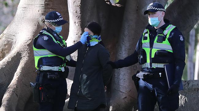 Police with a woman at an anti-mask protest at the Shrine in July. Picture: Alex Coppel