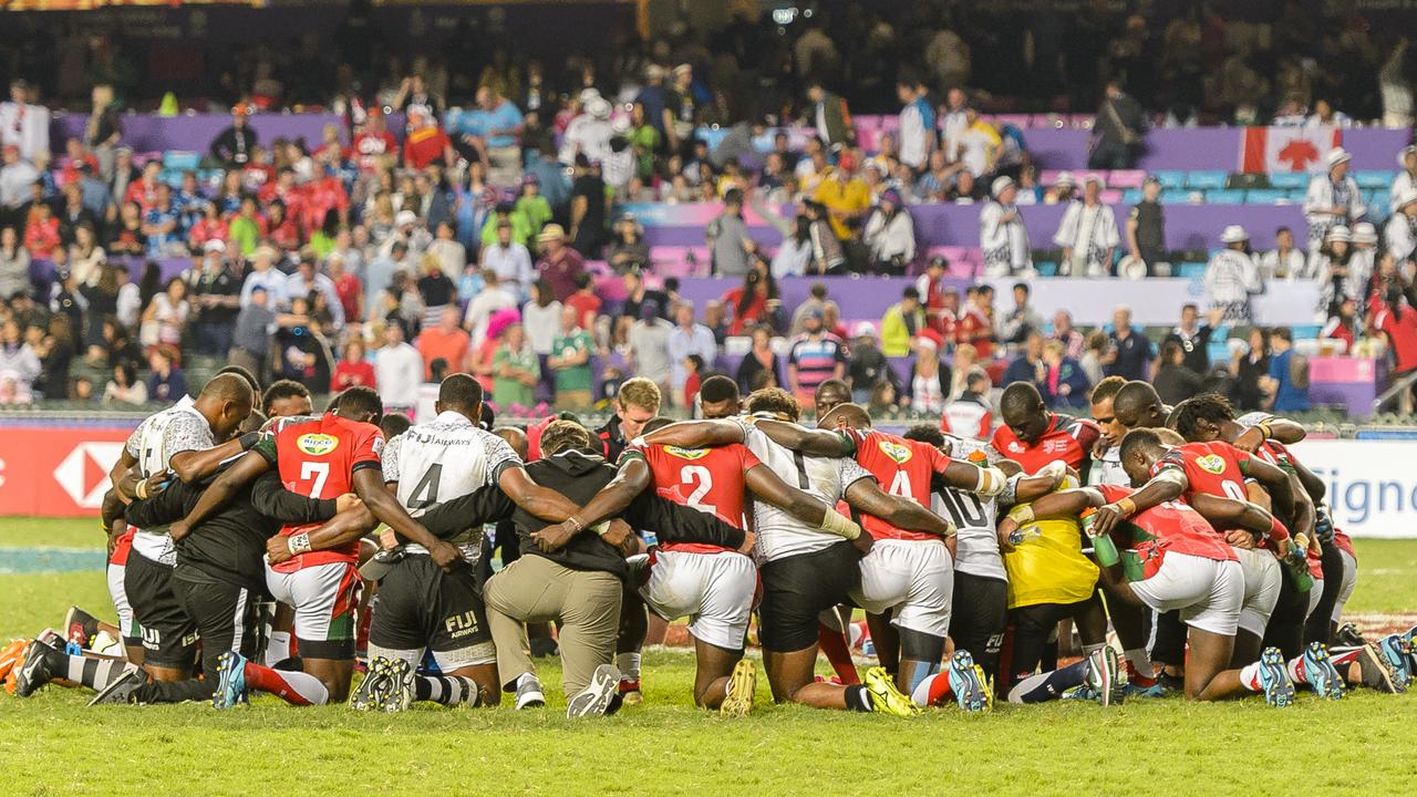 The Fiji and Kenya sevens teams pray together after the final in Hong Kong.