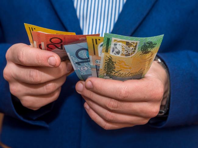 Male hands holding australias dollar banknotes closeup