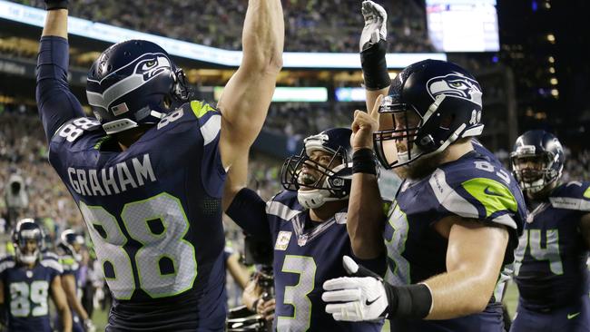 Seattle Seahawks quarterback Russell Wilson (centre) celebrates with tight end Jimmy Graham and offensive guard Mark Glowinsk.