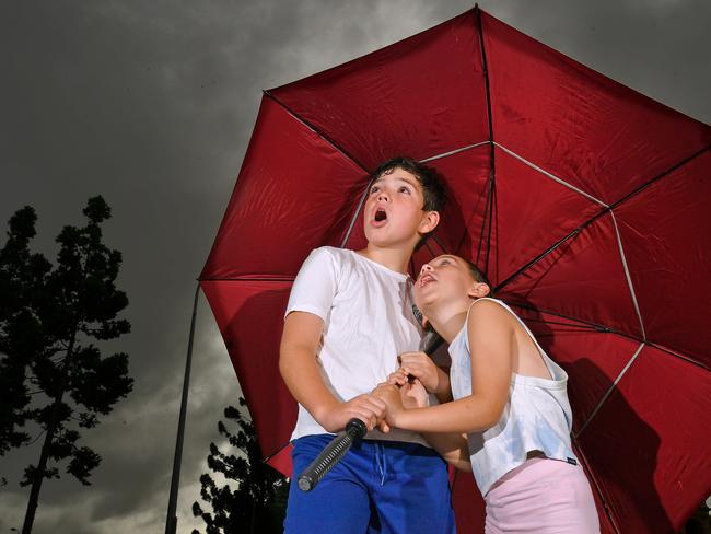 Ten-year-old Connor Bezzina and seven-year-old Isabella Bezzina look to the skies for rain in Brisbane. Picture: NCA NewsWire / John Gass