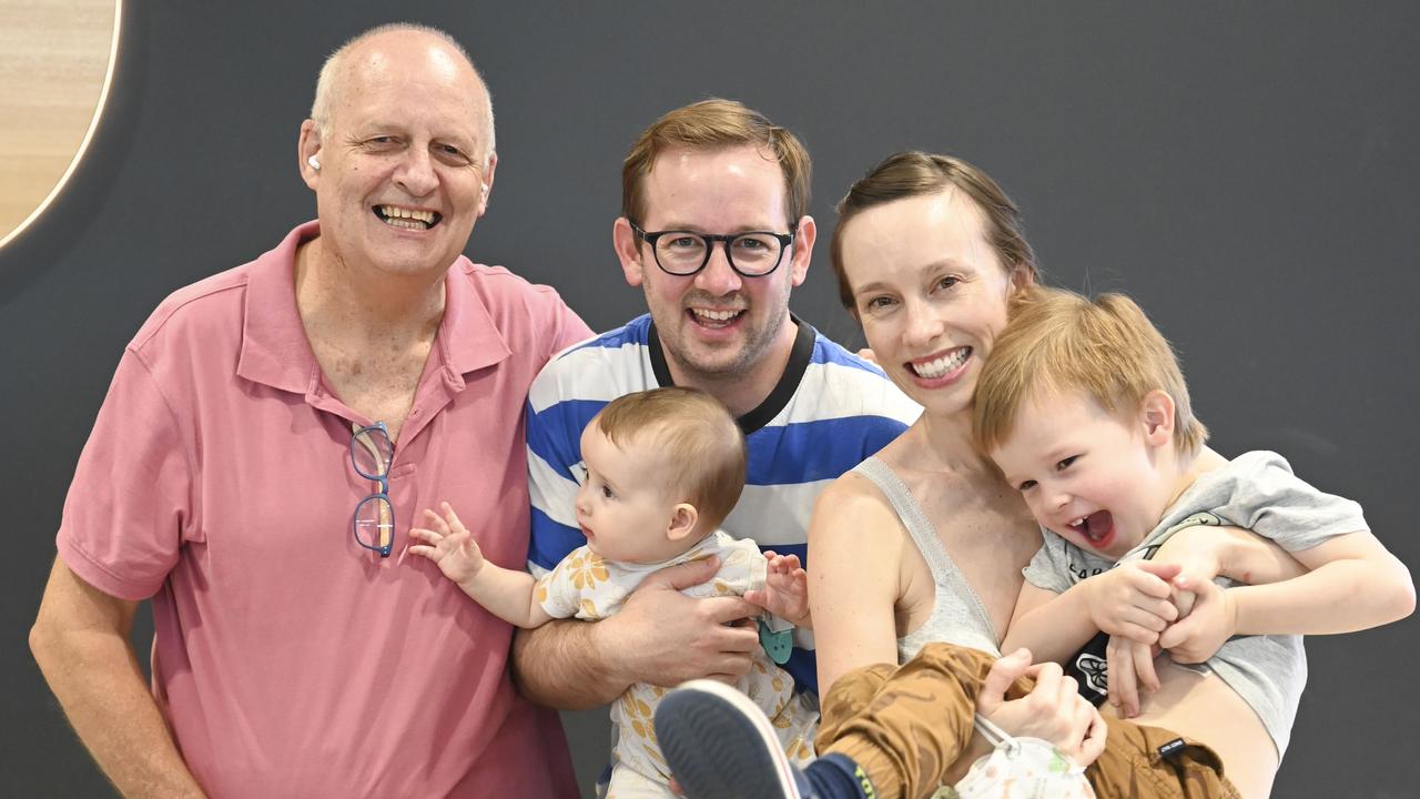 Steve Davis, left, greets son Ben, daughter-in-law Michelle Perks and his grandchildren Sidney, 4, and Poppy, eight months at Sydney airport. Picture: Darren Leigh Roberts