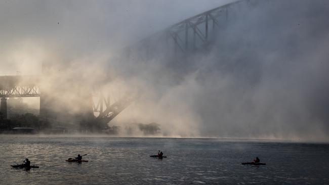 Kayakers paddle through still waters and misty atmosphere. Picture: Julian Andrews