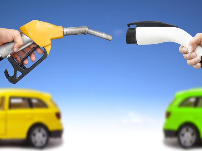 electric car and gasoline car concept. hand holding gas pump and power connector for refuel