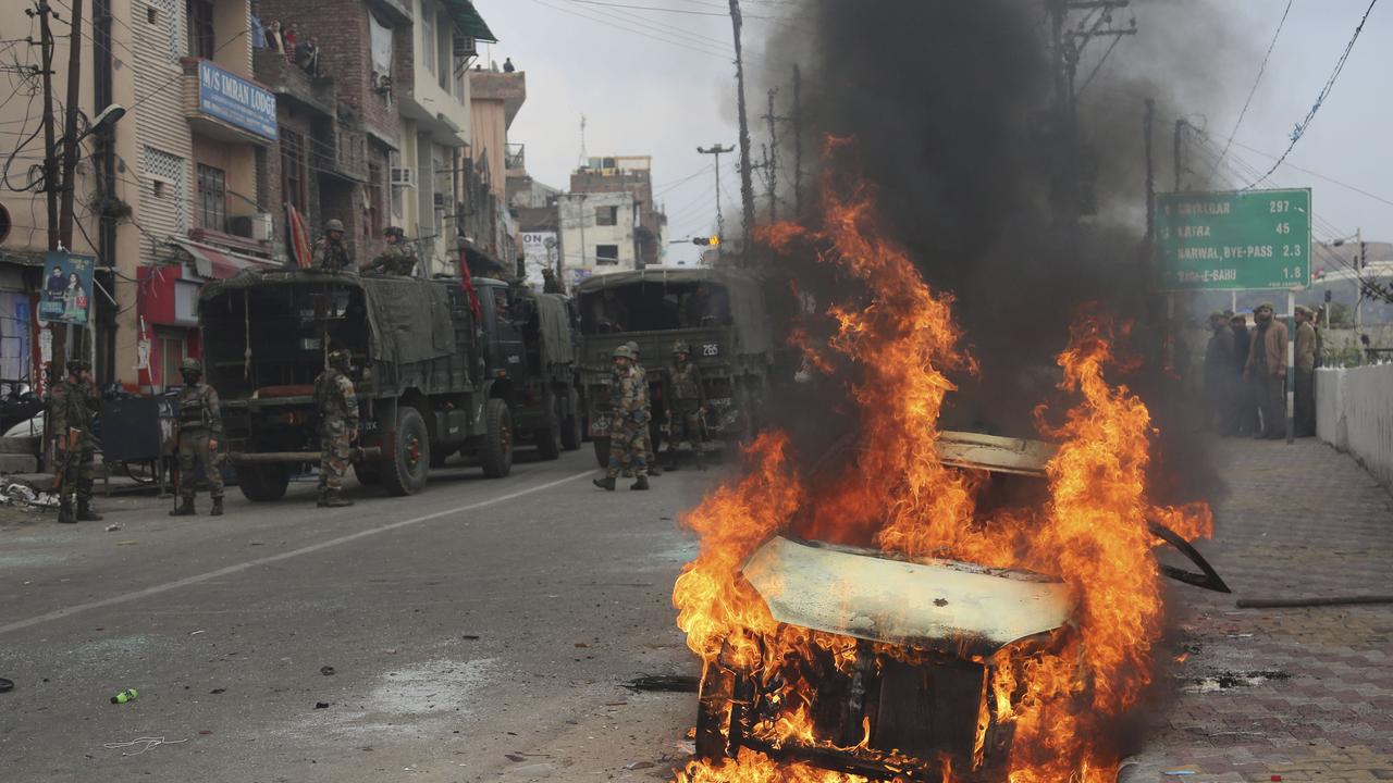 Indian army soldiers patrol near a vehicle set on fire by a mob during a protest in Jammu against Thursday’s attack on a paramilitary convoy. Picture: Channi Anand/AP