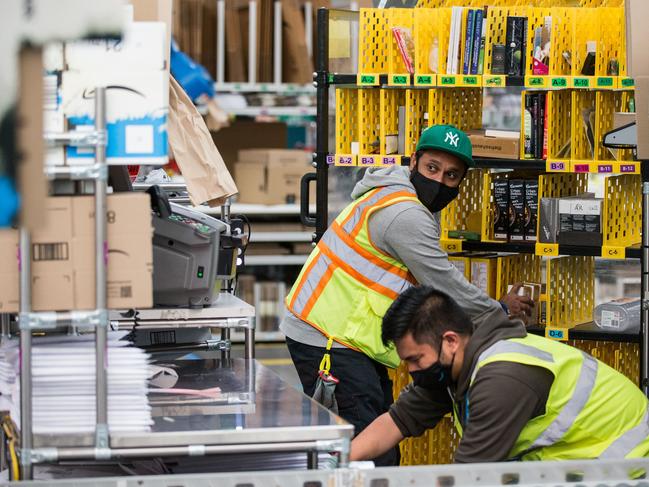 Charles Atulugama working with a colleague at Amazon Fulfillment Center MEL1 on April 28 , 2021, Melbourne, Australia. Picture:  Supplied/Darrian Traynor