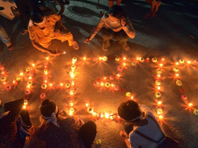 Cambodian residents light candles as they pray for the missing. Picture: AFP