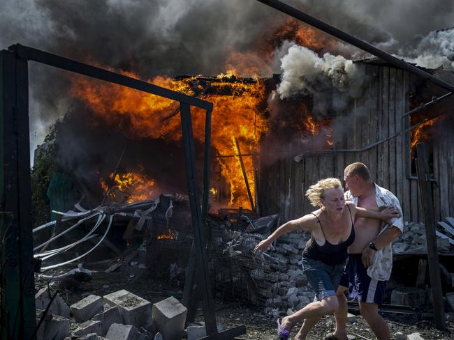 Long-Term Projects - First Prize © Valery Melnikov, Rossiya Segodnya Title: Black Days Of Ukraine Photo caption: Civilians escape from a fire at a house destroyed by an air attack in the Luhanskaya village. Story: Ordinary people became victims of the conflict between self-proclaimed republics and the official Ukrainian authorities from 2014 onwards in the region of Donbass. Disaster came into their lives unexpectedly. These people were involved in the military confrontation against their will. They experienced the most terrible things: the death of their friends and relatives, destroyed homes and the ruined lives of thousands of people.