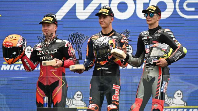 Le Mans 2025 Moto3 Winner Red Bull KTM Tech3 team’s Jose Antonio Rueda (C), celebrates on the podium flanked by third placed Liqui Moly Dynavolt Intact GP team’s David Munoz (R), and second placed LEVEL UP – MTA team’s Joel Kelso – May 11, 2025. Picture: Loic Venance / AFP