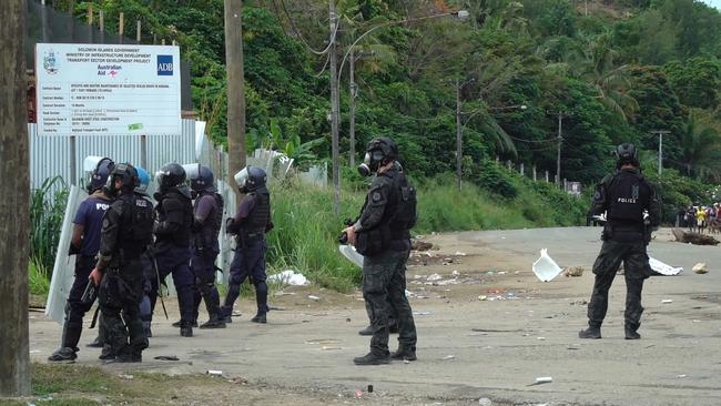 A framegrab shows Australian Federal Police officers patrolling with local police in Honiara on November 26, 2021 after two days of rioting which saw thousands ignore a government lockdown order, torching several buildings around the Chinatown district including commercial properties and a bank branch. (Photo by Jay Liofasi / AFP)