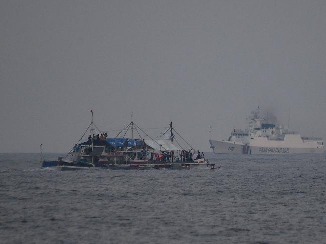 A China Coast Guard ship (R) sailing past a Philippine fishing boat with volunteers from the civilian-led mission Atin Ito Coalition on board, in the disputed South China Sea on May 15. Picture: AFP