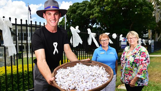 Ignatius Park College year 11 student Wayne Owens, 16, holds the 1100 white ribbons which Soroptimist Group volunteers Janet Askern and Sandra Crook made with the help of fellow group members. Picture: Shae Beplate.