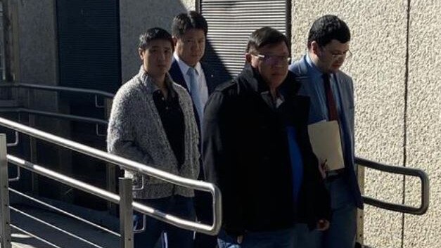 Jenn Huei Ting (third from left, with glasses and wearing a black coat and white running shoes) leaves the court with legal counsel. Picture: Supplied