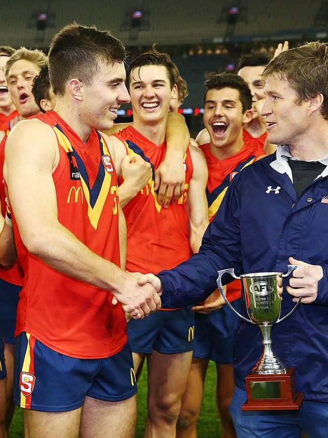 South Australia captain Luke Valente is presented with the cup by former Brisbane and Giants champ Luke Power. Picture: Michael Dodge/Getty Images