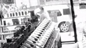 Two men are seen scuffling behind shop items. 