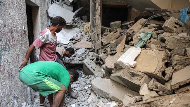 Men search through the rubble of the house of the sister of Ismail Haniyeh. Picture: AFP