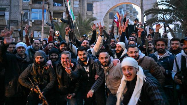 Local residents celebrate as they gather on a street in the Damascus suburb of Jaramana. Picture: AFP