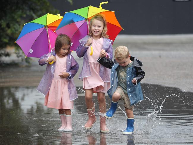 Indi, Ella and Austin Crampton enjoy the wet weather in 2022. Picture: Annette Dew