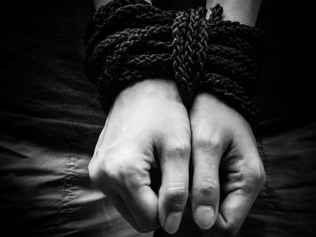 Hands of a missing kidnapped, abused, hostage, victim woman tied up with rope in emotional stress and pain, afraid, restricted, trapped, call for help, struggle, terrified, locked in a cage cell.