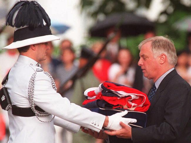 Chris Patten, right, the 28th and last governor of Hong Kong, receives the Union Jack flag after it was lowered at his official residence on June 30, 1997, when Britain returned the territory to China. Picture: AFP