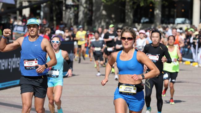 People pictured crossing the finish line of the 2024 Sydney Marathon at the Sydney Opera House. Picture: NewsWire / Damian Shaw